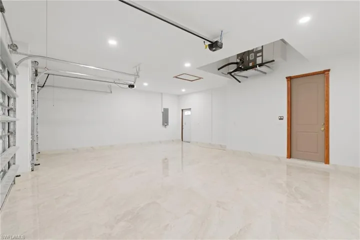 Garage featuring a garage door opener and electric panel