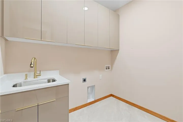 Laundry area featuring sink, cabinets, hookup for a washing machine, and electric dryer hookup