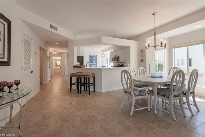Dining area featuring baseboards, visible vents, and a notable chandelier