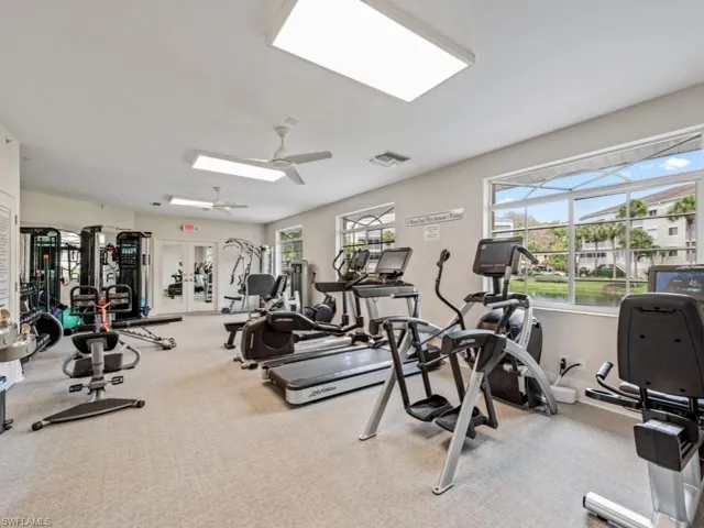 Exercise room with light carpet, ceiling fan, and visible vents
