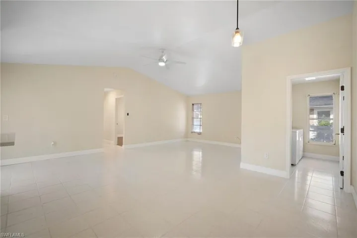 Unfurnished room with a wealth of natural light, washer / clothes dryer, ceiling fan, and lofted ceiling