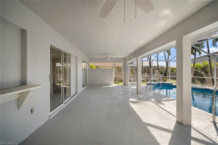 Unfurnished sunroom with ceiling fan and a swimming pool