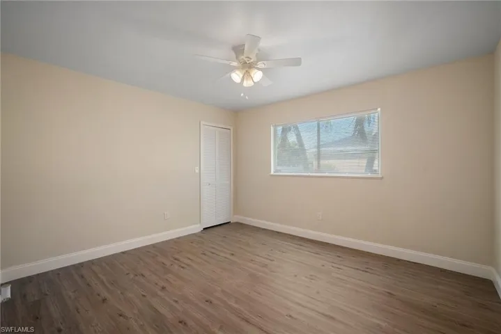 Spare room with a ceiling fan, baseboards, and wood finished floors