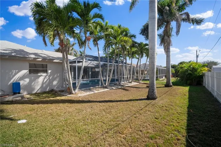View of yard with fence and a lanai