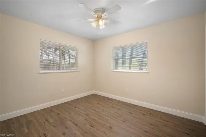 Spare room with a ceiling fan, baseboards, and wood finished floors