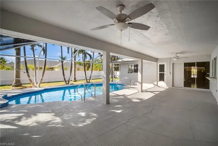 View of swimming pool featuring a ceiling fan, a lanai, a fenced backyard, and a patio