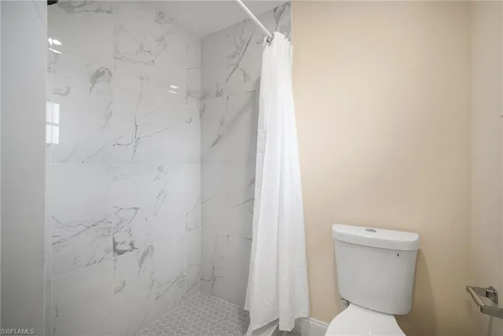 Bathroom featuring toilet and a stall shower