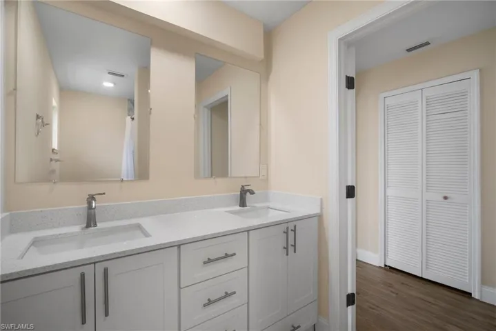 Full bathroom with double vanity, a sink, and visible vents