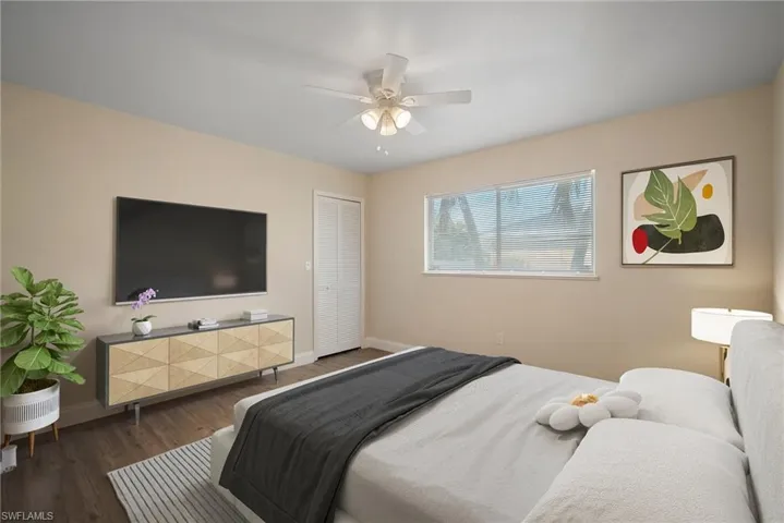 Bedroom with dark wood-type flooring, a closet, ceiling fan, and baseboards