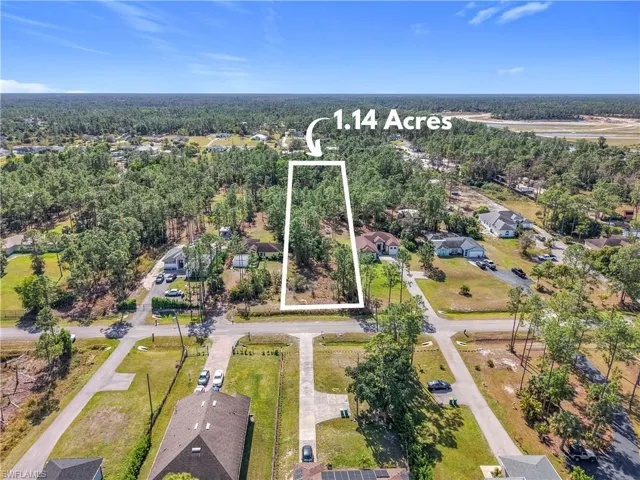 Aerial view of residential area with a heavily wooded area and property parcel outlined