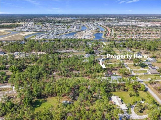 Aerial view of property's location with a nearby body of water and nearby suburban area