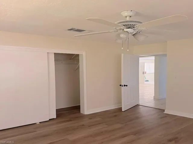 Unfurnished bedroom with light wood-type flooring, a ceiling fan, and a closet