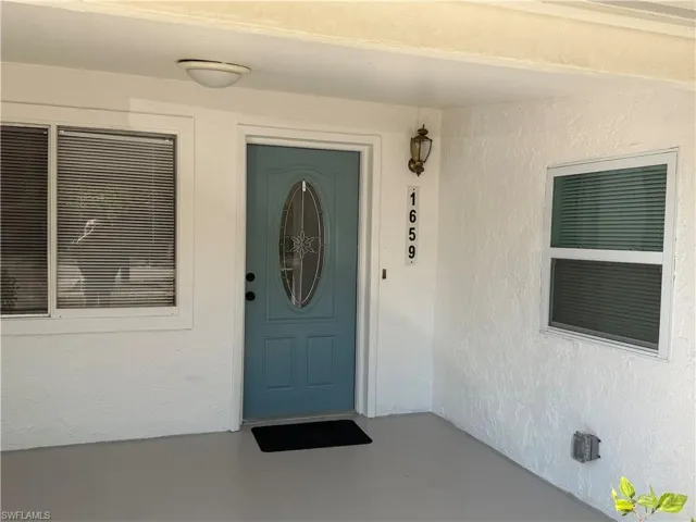 Entrance to property featuring stucco siding