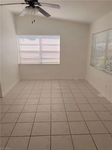 Unfurnished room with light tile patterned flooring, ceiling fan, and healthy amount of natural light