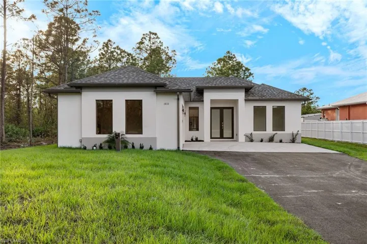 Back of property featuring a yard and french doors
