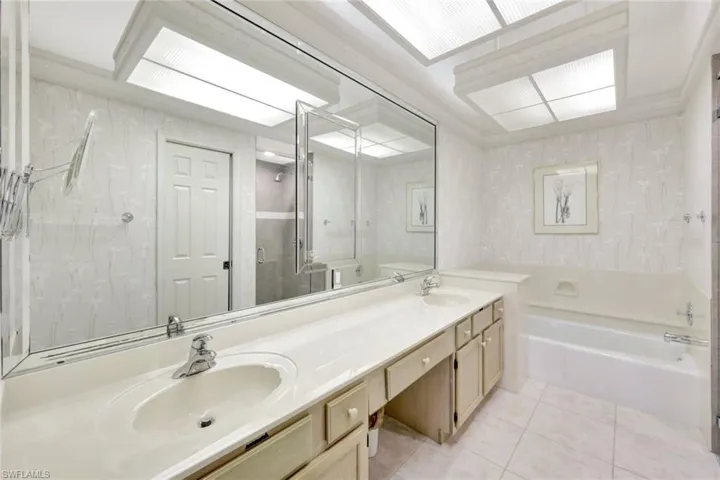 Bathroom featuring tile patterned flooring, vanity, and independent shower and bath