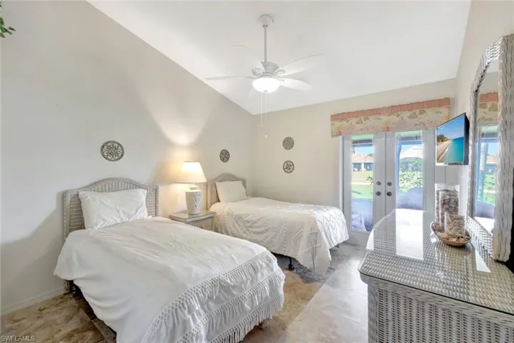 Tiled bedroom with vaulted ceiling, access to exterior, ceiling fan, and french doors