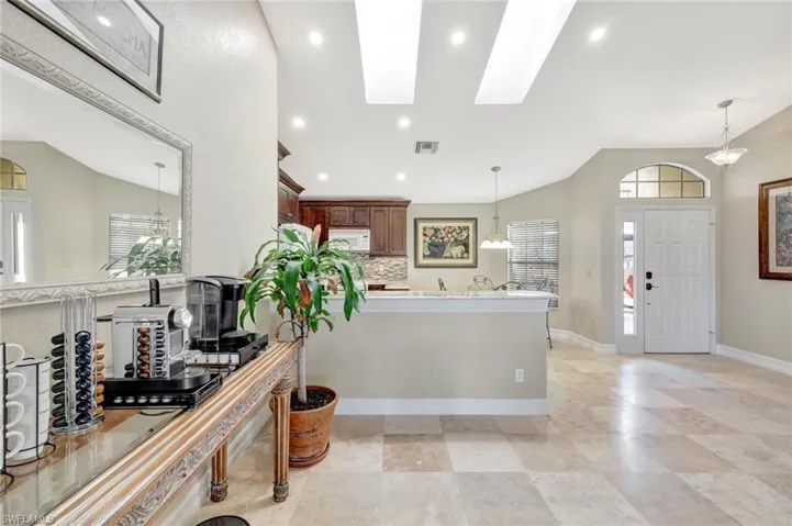Kitchen featuring pendant lighting, lofted ceiling with skylight, and tasteful backsplash