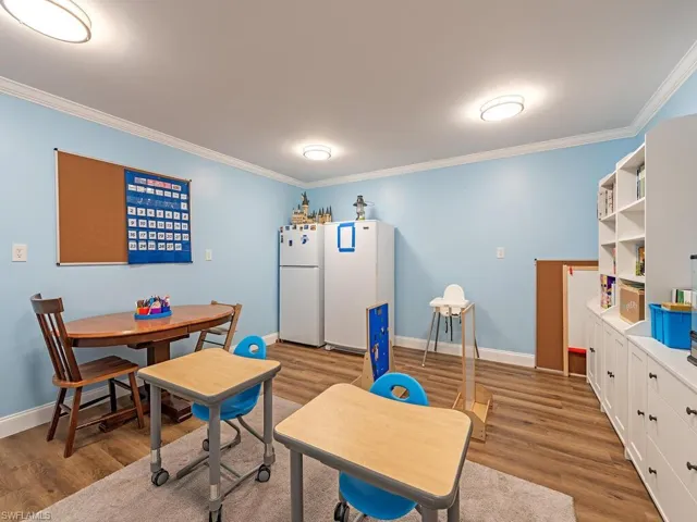 Dining room with ornamental molding, wood finished floors, and baseboards