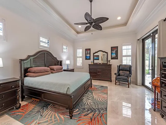 Bedroom with multiple windows, access to exterior, ornamental molding, a tray ceiling, and recessed lighting