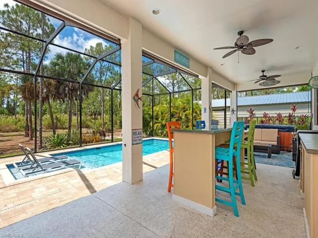 Outdoor pool with a covered hot tub, a patio, a lanai, and ceiling fan