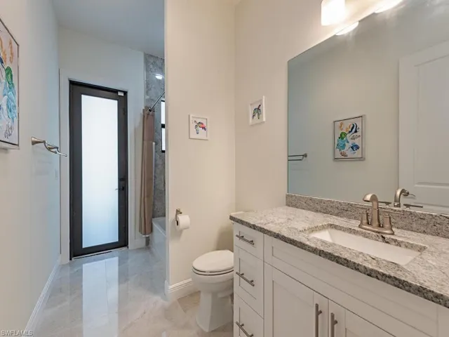 Bathroom featuring vanity, toilet, shower / bath combination with curtain, baseboards, and tile patterned floors