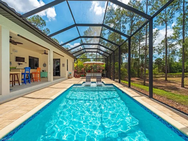 Outdoor pool with a patio, a ceiling fan, and glass enclosure