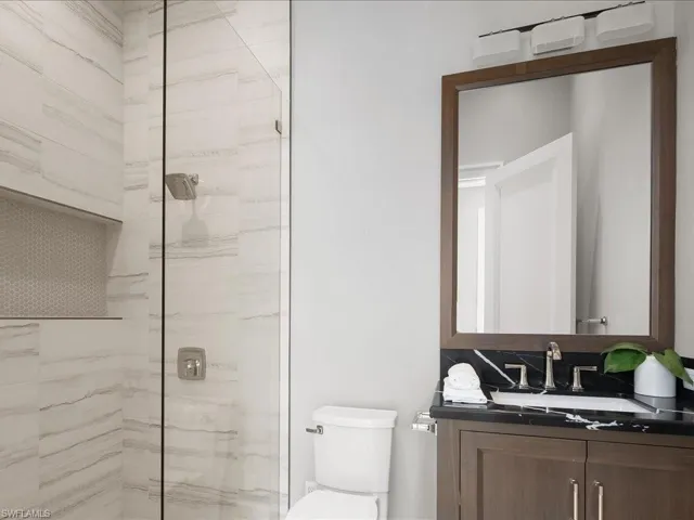 Full bathroom with vanity, toilet, and tiled shower