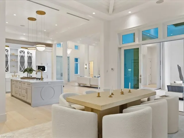 Dining space with visible vents, light wood-style floors, a towering ceiling, and recessed lighting