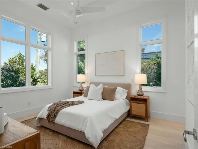 Bedroom featuring light wood-type flooring, baseboards, and visible vents