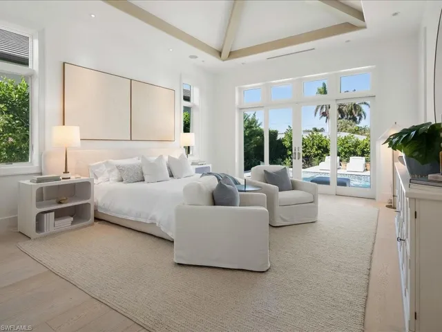 Bedroom with beam ceiling, light wood finished floors, access to outside, a towering ceiling, and recessed lighting