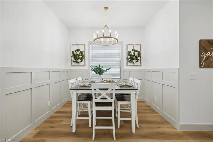 Dining space with light hardwood / wood-style floors and an inviting chandelier
