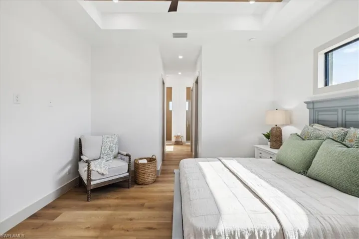 Bedroom featuring wood-type flooring, ceiling fan, and a tray ceiling