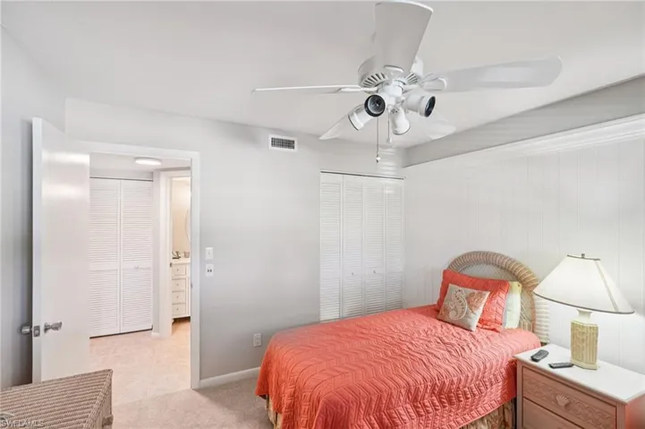 Bedroom featuring a closet, light carpet, and ceiling fan