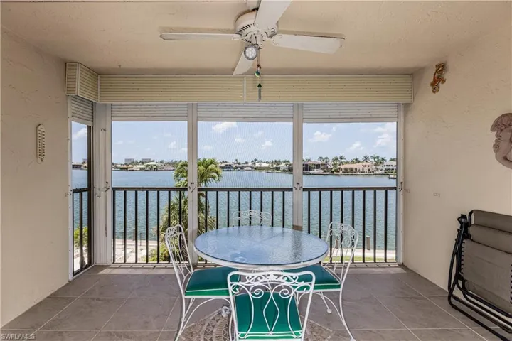 Sunroom featuring a water view and ceiling fan