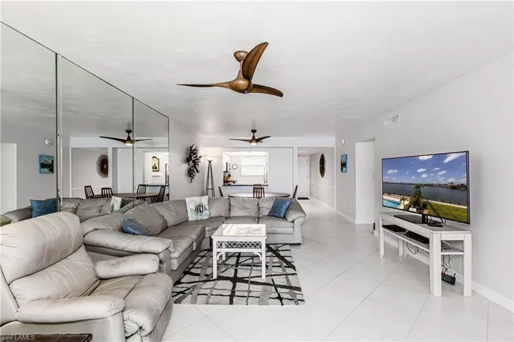 Living area featuring light tile patterned floors and a ceiling fan