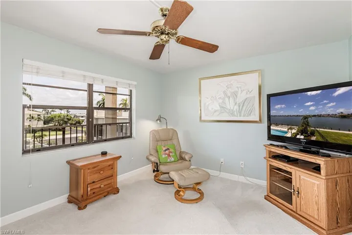 Sitting room featuring light carpet and ceiling fan