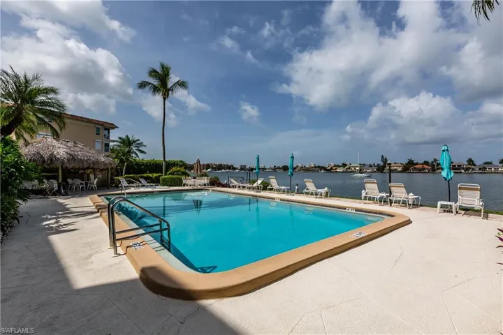 Community pool with a patio area and a water view
