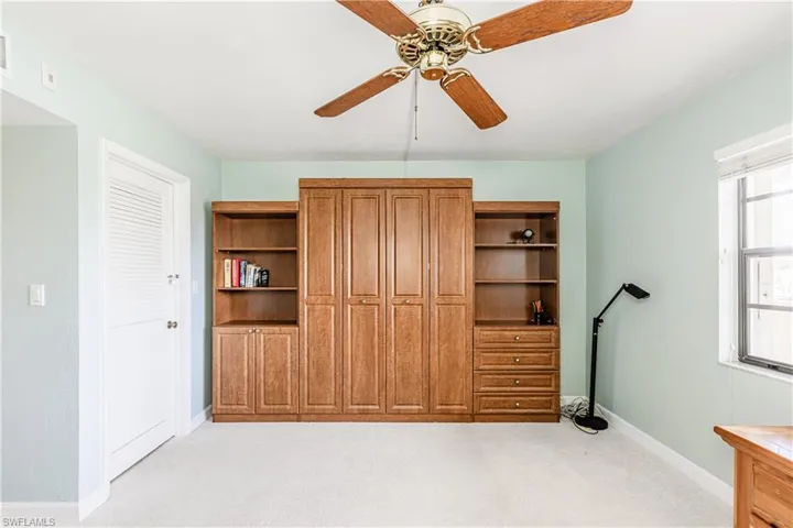 Bedroom with light carpet and a ceiling fan