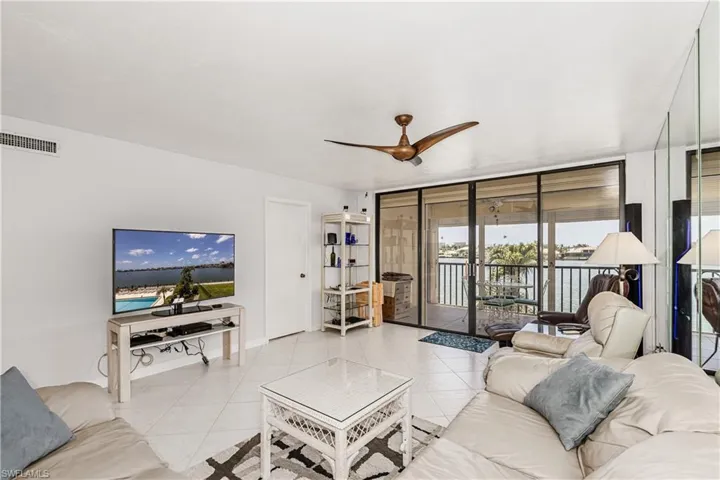 Living area featuring floor to ceiling windows, ceiling fan, and tile patterned floors
