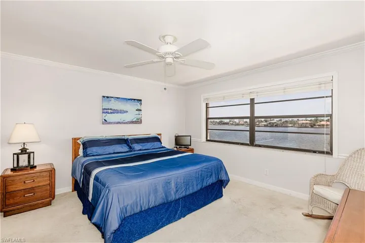 Bedroom featuring crown molding, carpet floors, and ceiling fan
