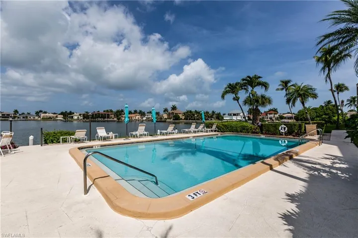 Community pool with a patio area and a water view