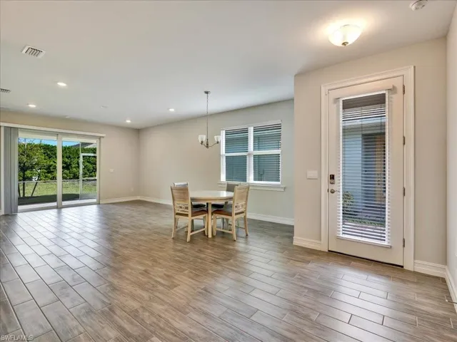 Dining room with wood finish floors, a chandelier, and recessed lighting
