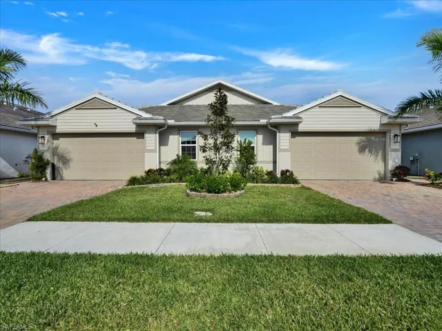 Ranch-style home featuring a front yard, stucco siding, and decorative driveway