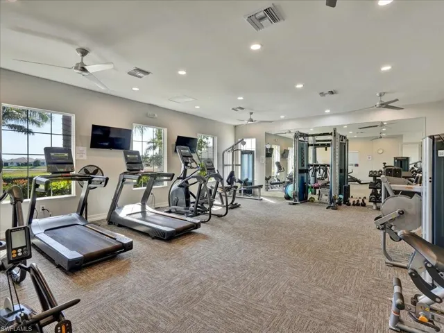 Workout area with a ceiling fan and recessed lighting