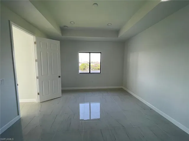 Spare room featuring light tile patterned flooring and a raised ceiling