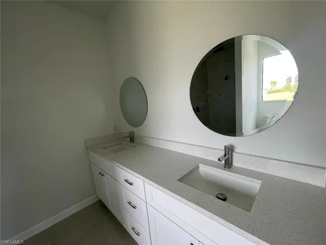Bathroom with double vanity and tile patterned flooring