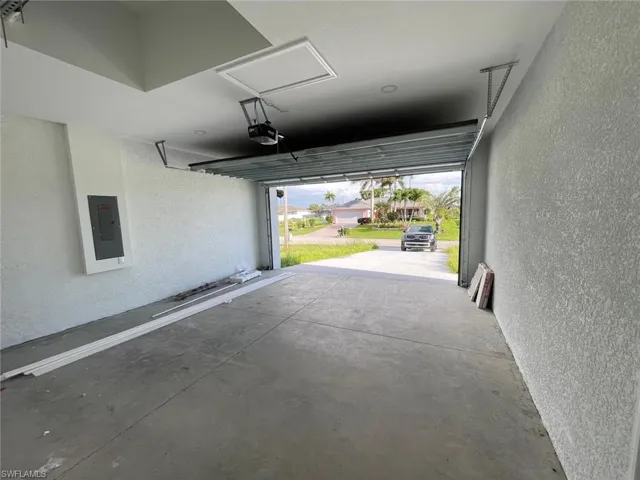 Garage with electric panel and a garage door opener