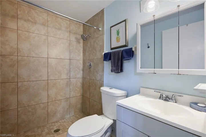 Bathroom with vanity and tiled shower