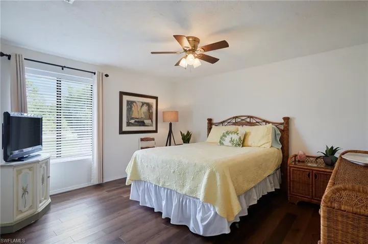Bedroom with dark wood-style floors and a ceiling fan